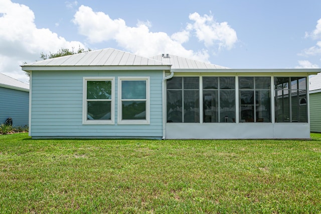 424 NE Leaping Frog Way, Port Saint Lucie, FL 34983 - rear view of house with a sunroom, a yard, and metal roof