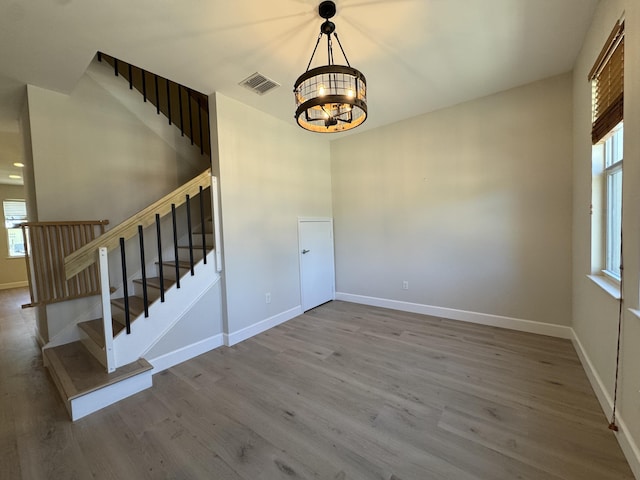 2799 Saranac Ave, West Palm Beach, FL 33409 - stairway featuring a chandelier and wood finished floors