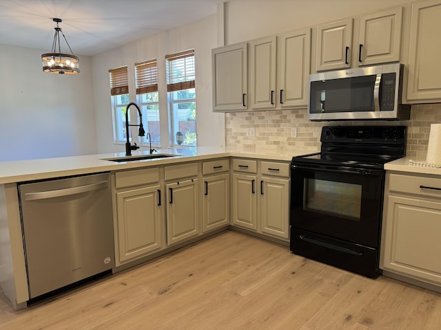 2799 Saranac Ave, West Palm Beach, FL 33409 - kitchen with appliances with stainless steel finishes, a peninsula, light wood-style flooring, light countertops, and backsplash