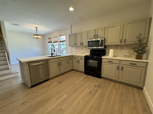 2799 Saranac Ave, West Palm Beach, FL 33409 - kitchen featuring stainless steel appliances, a peninsula, tasteful backsplash, light wood-style floors, and recessed lighting
