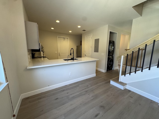 2799 Saranac Ave, West Palm Beach, FL 33409 - kitchen featuring stacked washing machine and dryer, recessed lighting, freestanding refrigerator, electric panel, and wood finished floors