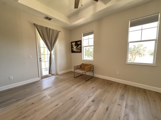 2799 Saranac Ave, West Palm Beach, FL 33409 - empty room featuring a tray ceiling, a ceiling fan, and light wood finished floors