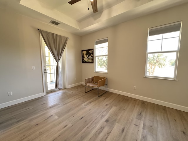 2799 Saranac Ave, West Palm Beach, FL 33409 - empty room featuring a tray ceiling, a ceiling fan, and light wood-style flooring