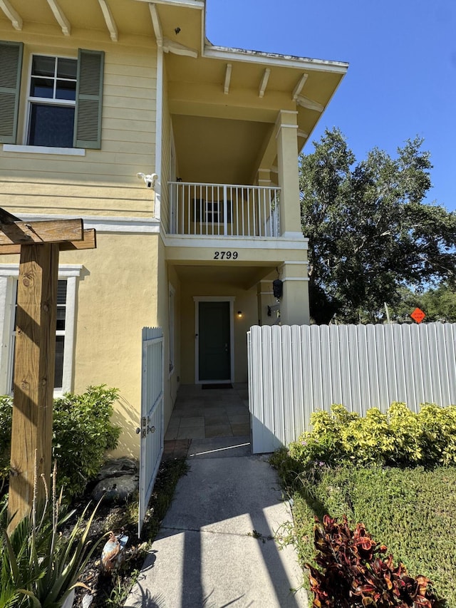 2799 Saranac Ave, West Palm Beach, FL 33409 - entrance to property with a balcony, a security system, and stucco siding
