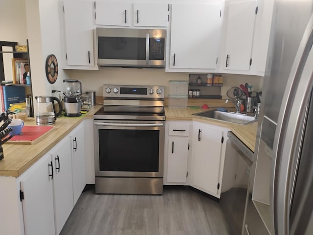 3531 Tall Pine Way Unit B-2, Greenacres, FL 33463 - kitchen featuring stainless steel appliances, light countertops, wood finished floors, and white cabinetry