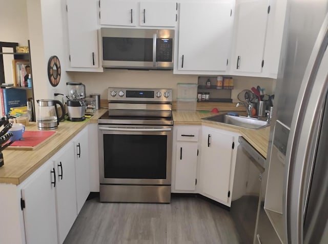 3531 Tall Pine Way Unit B-2, Greenacres, FL 33463 - kitchen featuring stainless steel appliances, light countertops, white cabinets, and wood finished floors
