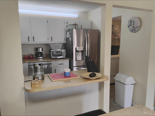 3531 Tall Pine Way Unit B-2, Greenacres, FL 33463 - kitchen with stainless steel appliances, white cabinetry, a kitchen breakfast bar, a peninsula, and light countertops