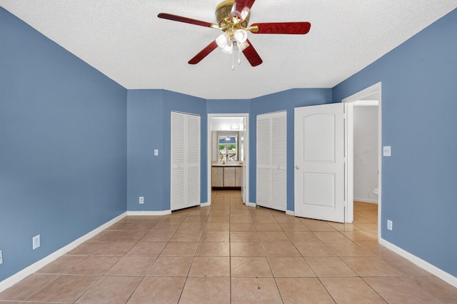 3 Ripley Way, Boynton Beach, FL 33426 - unfurnished bedroom with two closets, light tile patterned floors, a textured ceiling, and a ceiling fan
