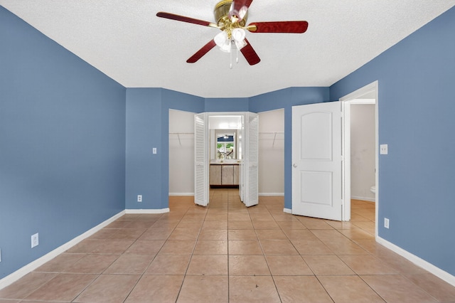 3 Ripley Way, Boynton Beach, FL 33426 - unfurnished bedroom featuring multiple closets, a textured ceiling, light tile patterned floors, and a ceiling fan