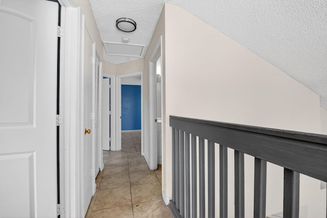 3 Ripley Way, Boynton Beach, FL 33426 - hallway featuring light tile patterned floors, a textured ceiling, and attic access
