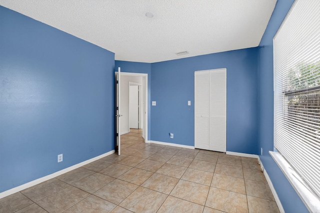 3 Ripley Way, Boynton Beach, FL 33426 - unfurnished bedroom with a textured ceiling, light tile patterned floors, and a closet