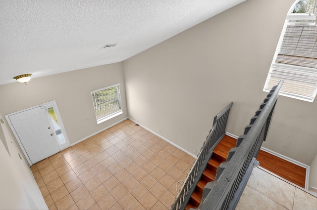 3 Ripley Way, Boynton Beach, FL 33426 - entryway with light tile patterned flooring and a textured ceiling