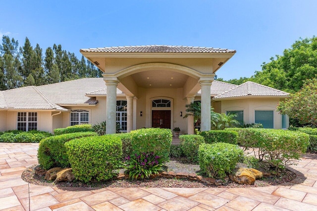 16164 Bridlewood Cir, Delray Beach, FL 33445 - view of exterior entry with stucco siding and a tiled roof