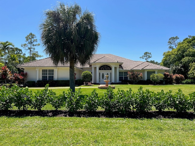 103 Squire Dr, Wellington, FL 33414 - view of front of house featuring a front yard, a tiled roof, and stucco siding