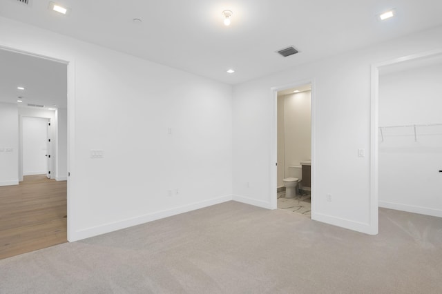 12870 Crane Xing, Palm Beach Gardens, FL 33412 - unfurnished bedroom with carpet flooring, a spacious closet, ensuite bathroom, and recessed lighting