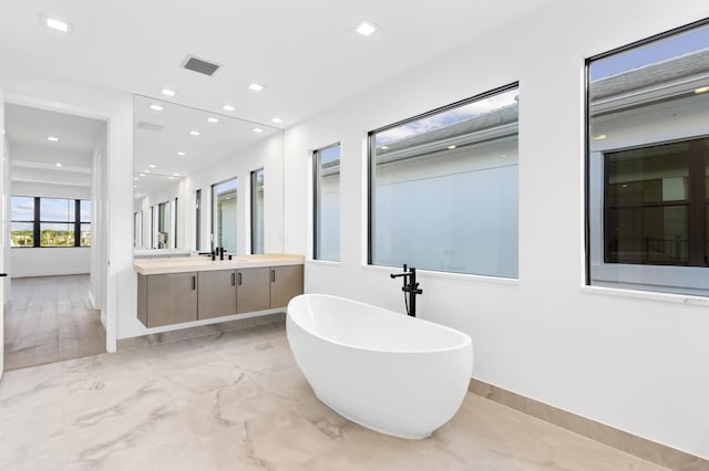 12870 Crane Xing, Palm Beach Gardens, FL 33412 - bathroom with a soaking tub, vanity, marble finish flooring, and recessed lighting