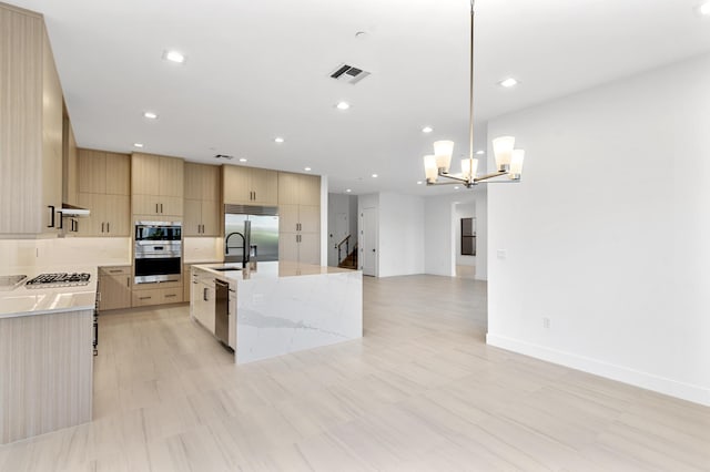 12870 Crane Xing, Palm Beach Gardens, FL 33412 - kitchen with built in appliances, modern cabinets, light brown cabinets, a chandelier, and open floor plan