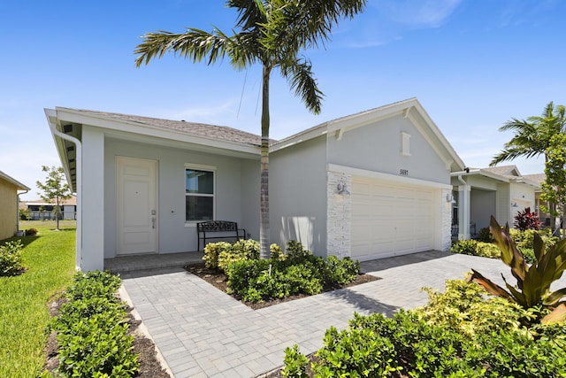5697 Graceful Way, Delray Beach, FL 33484 - ranch-style home with stucco siding, an attached garage, driveway, stone siding, and a front yard