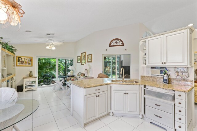 1350 SW 18th St, Boca Raton, FL 33486 - kitchen featuring lofted ceiling, open shelves, ceiling fan, light stone counters, and a peninsula