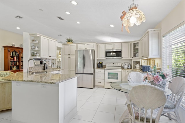 1350 SW 18th St, Boca Raton, FL 33486 - kitchen featuring appliances with stainless steel finishes, open shelves, a peninsula, vaulted ceiling, and light stone counters