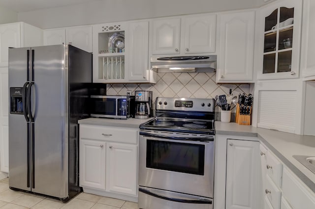925 SW All American Blvd, Palm City, FL 34990 - kitchen featuring appliances with stainless steel finishes, exhaust hood, light tile patterned floors, light countertops, and white cabinetry