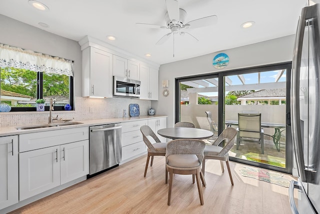 3596 Freshwater Dr, Jupiter, FL 33477 - kitchen with stainless steel appliances, decorative backsplash, white cabinetry, a ceiling fan, and light countertops