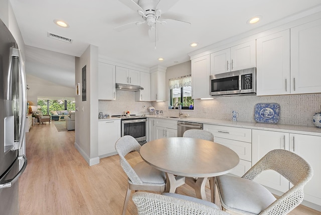 3596 Freshwater Dr, Jupiter, FL 33477 - kitchen with appliances with stainless steel finishes, under cabinet range hood, decorative backsplash, a ceiling fan, and white cabinets