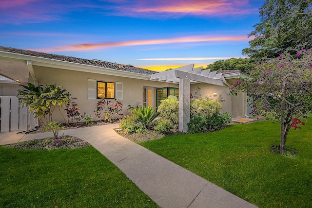 3596 Freshwater Dr, Jupiter, FL 33477 - view of front of home with stucco siding, a yard, and a pergola