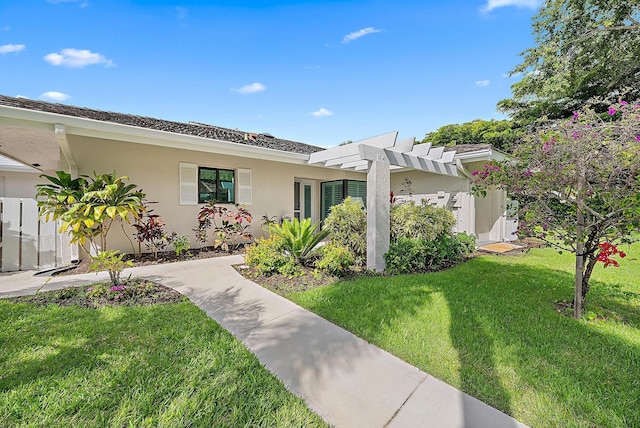 3596 Freshwater Dr, Jupiter, FL 33477 - view of front of property with a front lawn, stucco siding, and a pergola