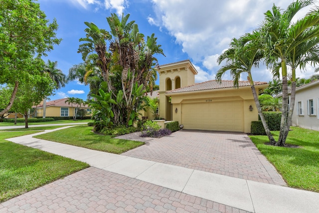 9724 Via Grandezza, Wellington, FL 33411 - mediterranean / spanish home with stucco siding, an attached garage, a front yard, and decorative driveway