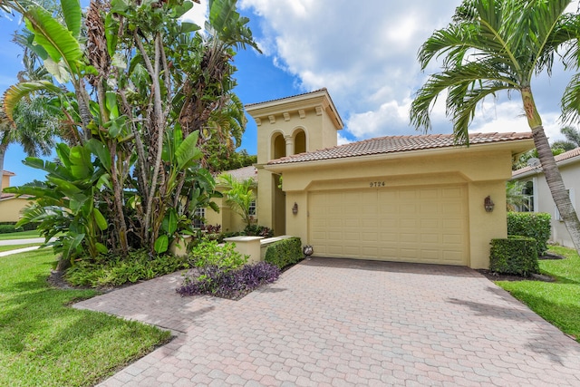 9724 Via Grandezza, Wellington, FL 33411 - mediterranean / spanish-style home with a tiled roof, stucco siding, decorative driveway, a garage, and a front yard