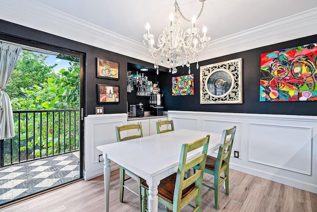 1605 S US Highway 1 Unit F202, Jupiter, FL 33477 - dining room featuring a chandelier, light wood-style floors, a decorative wall, ornamental molding, and wainscoting