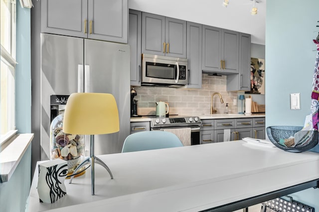 2 Colonial Club Dr Unit 203, Boynton Beach, FL 33435 - kitchen with stainless steel appliances, gray cabinets, decorative backsplash, light countertops, and plenty of natural light