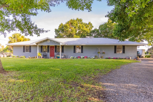 1450 SW 28th St, Okeechobee, FL 34974 - ranch-style house with covered porch, a front yard, stucco siding, and a metal roof