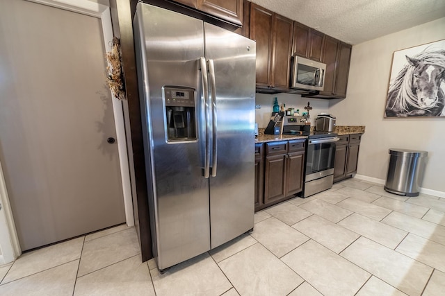 1450 SW 28th St, Okeechobee, FL 34974 - kitchen with appliances with stainless steel finishes, dark brown cabinets, a textured ceiling, stone counters, and light tile patterned flooring