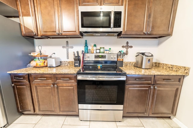 1450 SW 28th St, Okeechobee, FL 34974 - kitchen featuring stainless steel appliances, light tile patterned floors, and light stone countertops