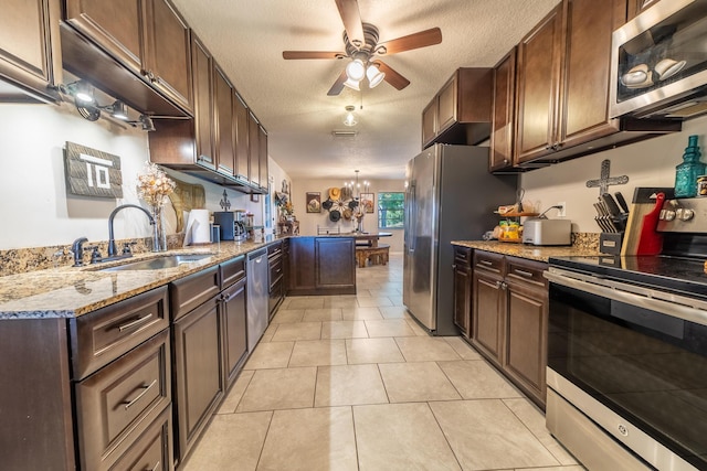 1450 SW 28th St, Okeechobee, FL 34974 - kitchen featuring appliances with stainless steel finishes, a ceiling fan, a peninsula, a textured ceiling, and light stone counters