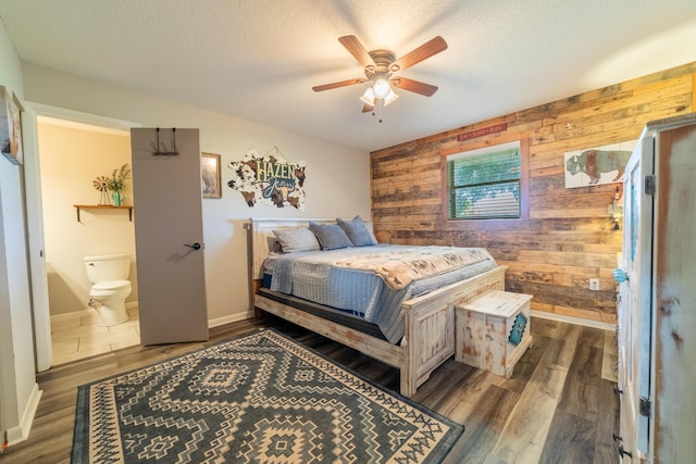 1450 SW 28th St, Okeechobee, FL 34974 - bedroom with wooden walls, an accent wall, ensuite bath, wood finished floors, and a textured ceiling