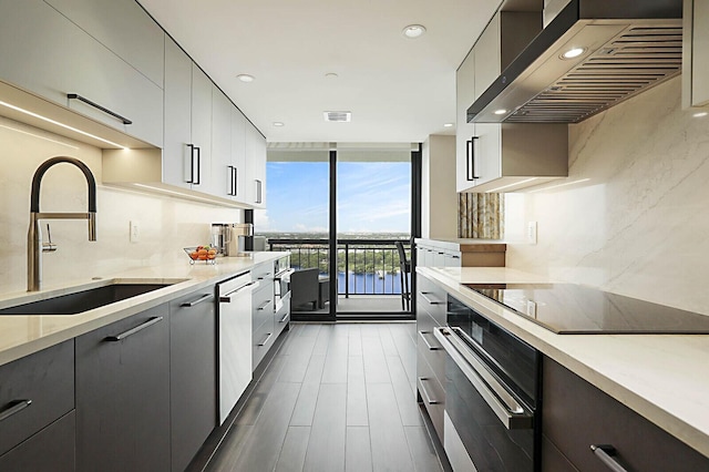 2001 N Ocean Blvd Unit 1804, Boca Raton, FL 33431 - kitchen with ventilation hood, stainless steel appliances, modern cabinets, floor to ceiling windows, and decorative backsplash