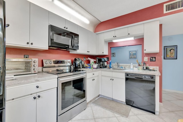 15401 Pembridge Ave Unit 9, Delray Beach, FL 33484 - kitchen featuring black appliances, light countertops, light tile patterned floors, and white cabinets