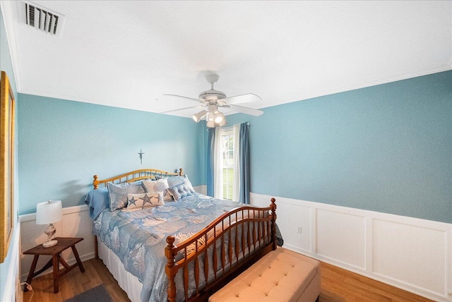 2990 SW Ventura St, Port Saint Lucie, FL 34953 - bedroom with wood finished floors, wainscoting, and a ceiling fan
