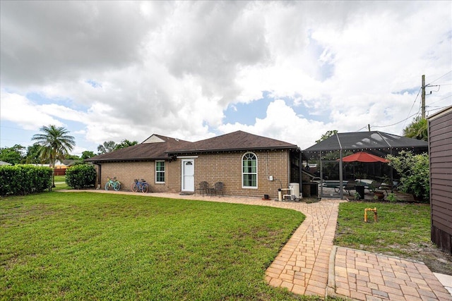 2990 SW Ventura St, Port Saint Lucie, FL 34953 - back of property with a patio area, brick siding, and a yard