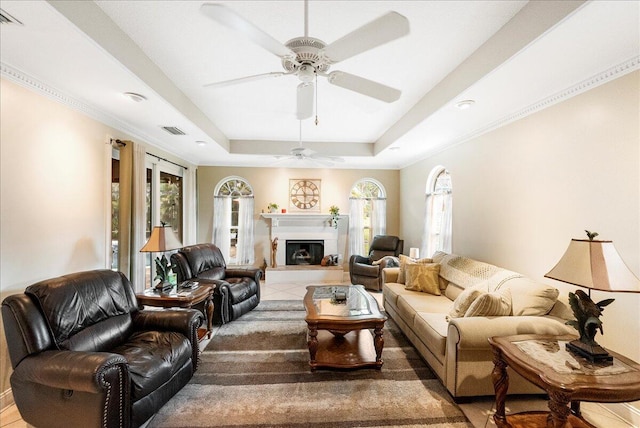 2990 SW Ventura St, Port Saint Lucie, FL 34953 - living area with a tray ceiling, a ceiling fan, and a fireplace with raised hearth
