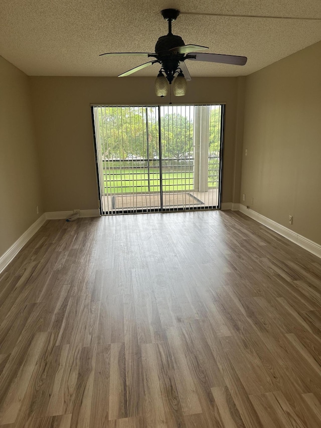 5917 Via Vermilya Unit 306, Lake Worth, FL 33462 - spare room featuring ceiling fan, healthy amount of natural light, wood finished floors, and a textured ceiling