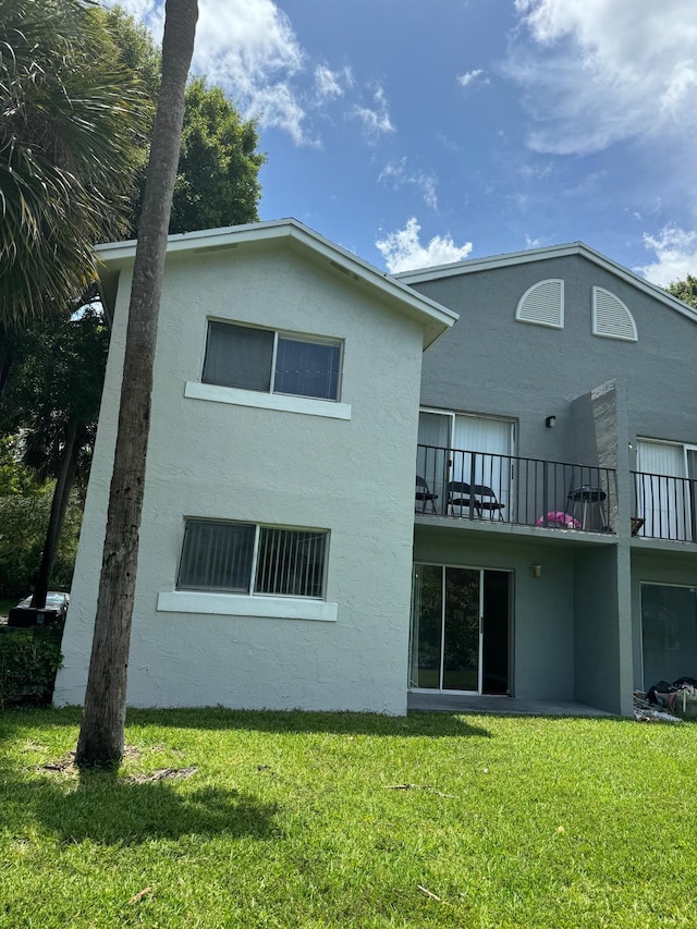 984 Lake Victoria Dr Unit B, West Palm Beach, FL 33411 - back of property with stucco siding, a yard, and a balcony