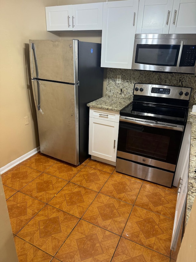984 Lake Victoria Dr Unit B, West Palm Beach, FL 33411 - kitchen featuring appliances with stainless steel finishes, white cabinets, light stone countertops, and backsplash