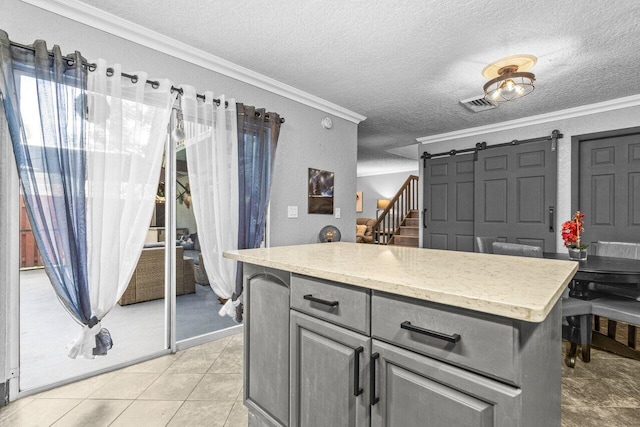 22180 Boca Rancho Dr Unit B, Boca Raton, FL 33428 - kitchen featuring ornamental molding, a textured ceiling, a barn door, gray cabinetry, and light tile patterned floors