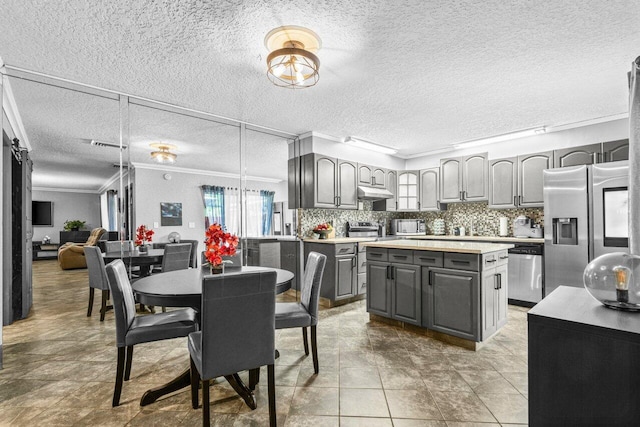 22180 Boca Rancho Dr Unit B, Boca Raton, FL 33428 - kitchen featuring gray cabinets, crown molding, stainless steel appliances, plenty of natural light, and a center island