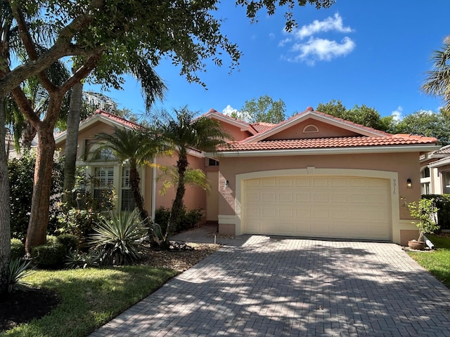 9916 E Tallyrand Dr, Lake Worth, FL 33467 - mediterranean / spanish home featuring stucco siding, an attached garage, decorative driveway, and a tiled roof