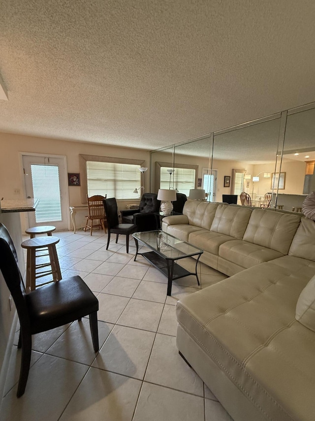 1046 Wolverton C, Boca Raton, FL 33434 - living area with a textured ceiling, light tile patterned floors, and healthy amount of natural light